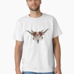 “Longhorn cow skull with feathers and roses in boho western style on rustic t-shirt – country girl aesthetic shirt design”
