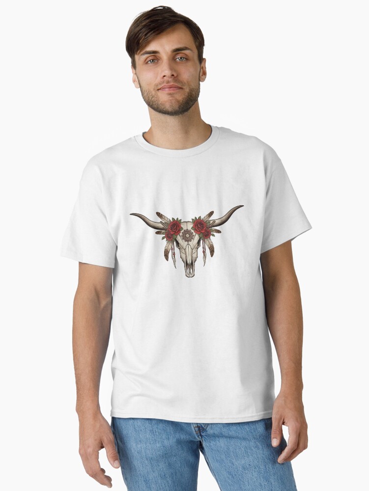 “Longhorn cow skull with feathers and roses in boho western style on rustic t-shirt – country girl aesthetic shirt design”